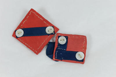 Two small pieces of cloth, red/blue with white buttons