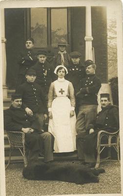 Ethel May Hennah, wearing British Red Cross uniform, with Belgian convalescent soldiers outside Oakley VAD Hospital in Bromley, Kent