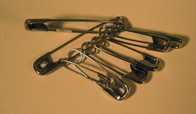 Eight safety pins of various sizes.