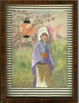 Framed embroidered picture of a woman in garden