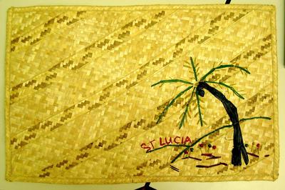 Decorative straw mat with a palm tree design from 'St Lucia'