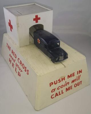 British Red Cross mechanical collecting box with roll out model ambulance: 'Push me in - a coin will call me out'; Fundraising/collecting box; 287/14/3(1)