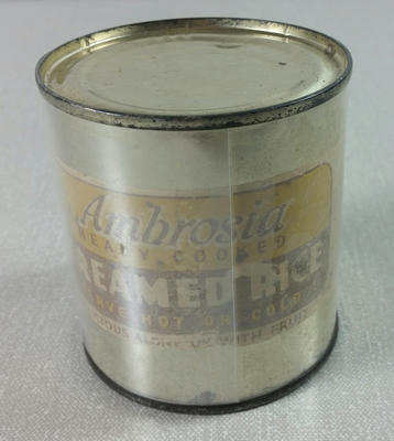 Empty tin with label, ' Ambrosia Creamed Rice'. Part of a collection of items which were used at the POW Exhibitions which were held during the Second World War.