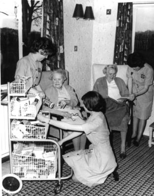 Junior Red Cross cadets take round a trolley shop in an old people's home