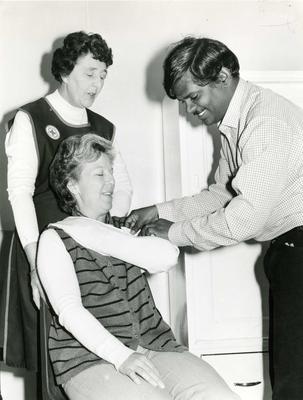 British Red Cross member instructing on how to tie a sling