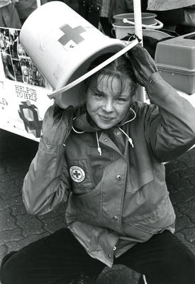British Red Cross Youth member with a collecting bucket over her head