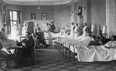 Hospital ward in a country house with lying-in and up-patients, two in wheelchairs