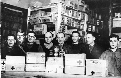 Prisoners of War from Ilag VIII displaying Red Cross food parcels and tins