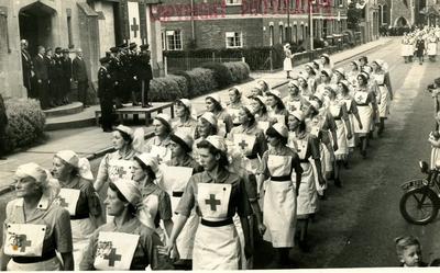 Groups of VADs from the Farnham Division, Surrey, marching past a Church