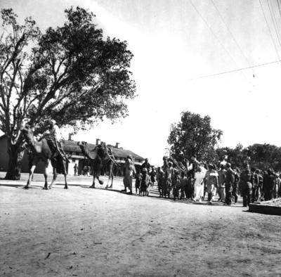 Black and white photograph. Lady Limerick and her entourage moving into the Multan Cantonment Camp in Pakistan surrounded by refugee adults and children