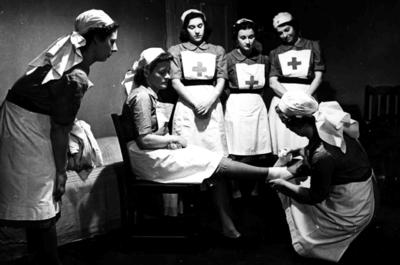 Black and white photograph. VADs practicing bandaging as part of training for the Stanley Shield
