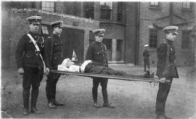 Photograph showing members of London/59 detachment carrying and escorting a stretcher