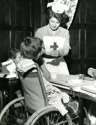 A nurse feeding a child at the Palace School in Ely