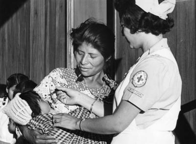 A Guatemalan Red Cross nurse giving an oral poliomyelitis vaccine to a child