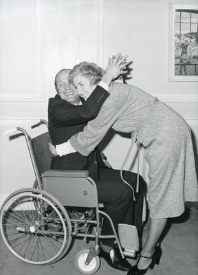 Black and white photograph used in Red Cross News of Dame Vera Lynn and Henry Cooper practising the correct way to lift a patient