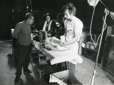 Black and white photograph from Red Cross News June 1976 of a doctor from the ICRC treating a young victim from the conflict in Lebanon