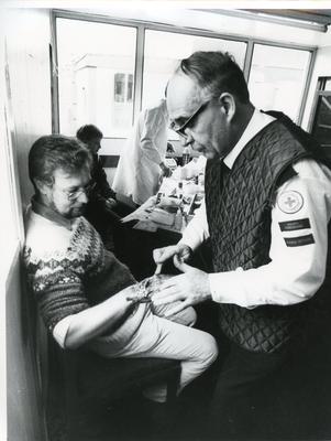 Black and white photograph of First Aid training with a casualty simulation