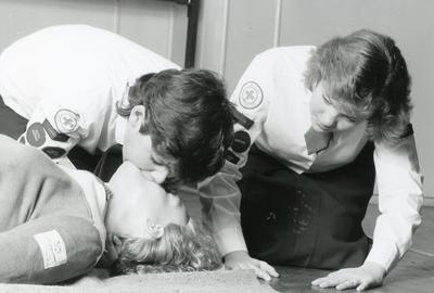 Black and white photograph of Red Cross Youth members learning resuscitation during first aid training