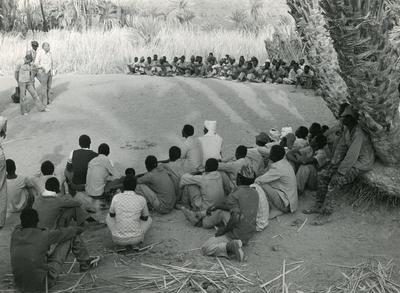 Black and white photograph of an ICRC delegate address a group of prisoners of war in Chad