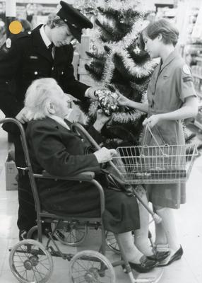 Black and white photograph of Youth and Juniors helping people with their Christmas shopping