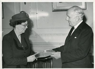 Black and white photograph of the Earl of Woolton presenting a retirement gift to Miss Warner