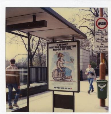 Colour photograph of a Red Cross poster advertising Red Cross Week at a central London bus stop