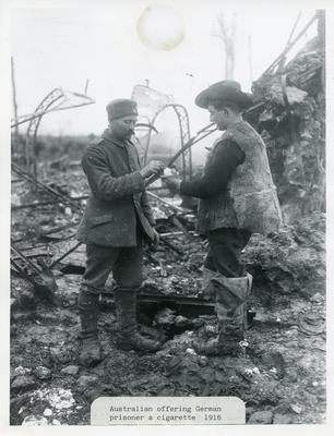 Black and white photograph of an Australian soldier offering a German prisoner a cigarette during the First World War