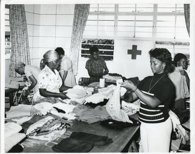 Black and white photograph of the Jamaican Red Cross sorting out clothing for victims of a Honduras hurricane
