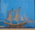 Small silver filigree sailing vessel in glass display case, of oriental design.