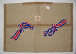 Presentation cloth bag with ties in red, white and blue ribbon. Bears tag 'A Gift from Queen Alexandra' and the Joint Committee emblem.