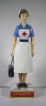 Royal Worcester figure of a British Red Cross VAD in indoor uniform carrying a First Aid bag