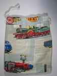 Comforts bag made from colourful cotton material depicting toys, with draw string top, and label 'BOYS'.