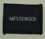 Navy blue cloth flash, to be worn on uniform by Red Cross Junior who holds a certificate in Messenger. With the words 'Messenger' in white.