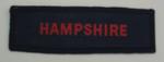 Navy blue County Branch cloth flash, with the word Hampshire in red.