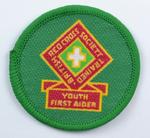 Green circular cloth badge: British Red Cross Society Trained Youth First Aider