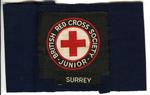 navy brassard with cloth badge: British Red Cross Society Junior, and additional cloth insignia 'Surrey'