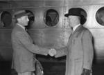 Black and white photograph. Major General Treffry Thompson shakes hands with Air-Marshal Sir Harold Whittingham, medical adviser to the British Red Cross, before his departure to India as British Red Cross commssioner for relief work with refugees in India and Pakistan