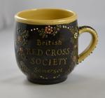 Ceramic slip-decorated mug with inscription 'British Red Cross Society Somerset'