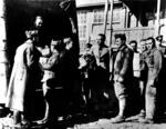 Red Cross parcels being distributed from a vehicle to a group of waiting prisoners of war