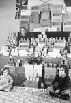 Jacqueline, Dianne and Jeanette Guise in front of their "shop" made from empty Red Cross parcels and tins
