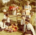 Cadets sitting next to a Flower Arranging Stall at a Fete