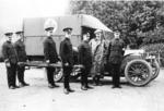 Ambulance bearing Red Cross emblem with British Red Cross members standing alongside