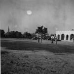 Black and white photograph. British Red Cross Society hospital wing pictured with vehicles in front, including a Red Cross ambulance, Pakistan