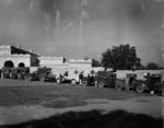Black and white photograph. British Red Cross ambulance convoy and drivers parked outside No1 Hospital in Multan, Pakistan