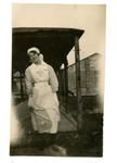 VAD member [Dorothy Hancock] in nursing uniform walking in the grounds of [Southmead Hospital, Bristol]
