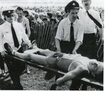 Black and white photograph of First Aid in action with help being given to an exhausted marathon runner