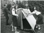 Black and white photograph of members of the Exeter Junior Red Cross putting up a tent at camp