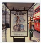 Colour photograph of a Red Cross poster advertising Red Cross Week at a central London bus stop