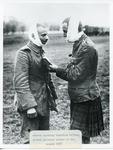 Black and white photograph of a German speaking Canadian telling the German prisoner the nature of his wounds