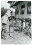 Black and white photograph of disabled children gardening near to the British Red Cross office in Malawi